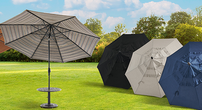 Four outdoor umbrellas in various colors on a grassy field.
