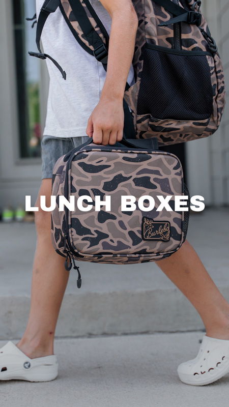 A person carrying a camo lunch box and backpack.