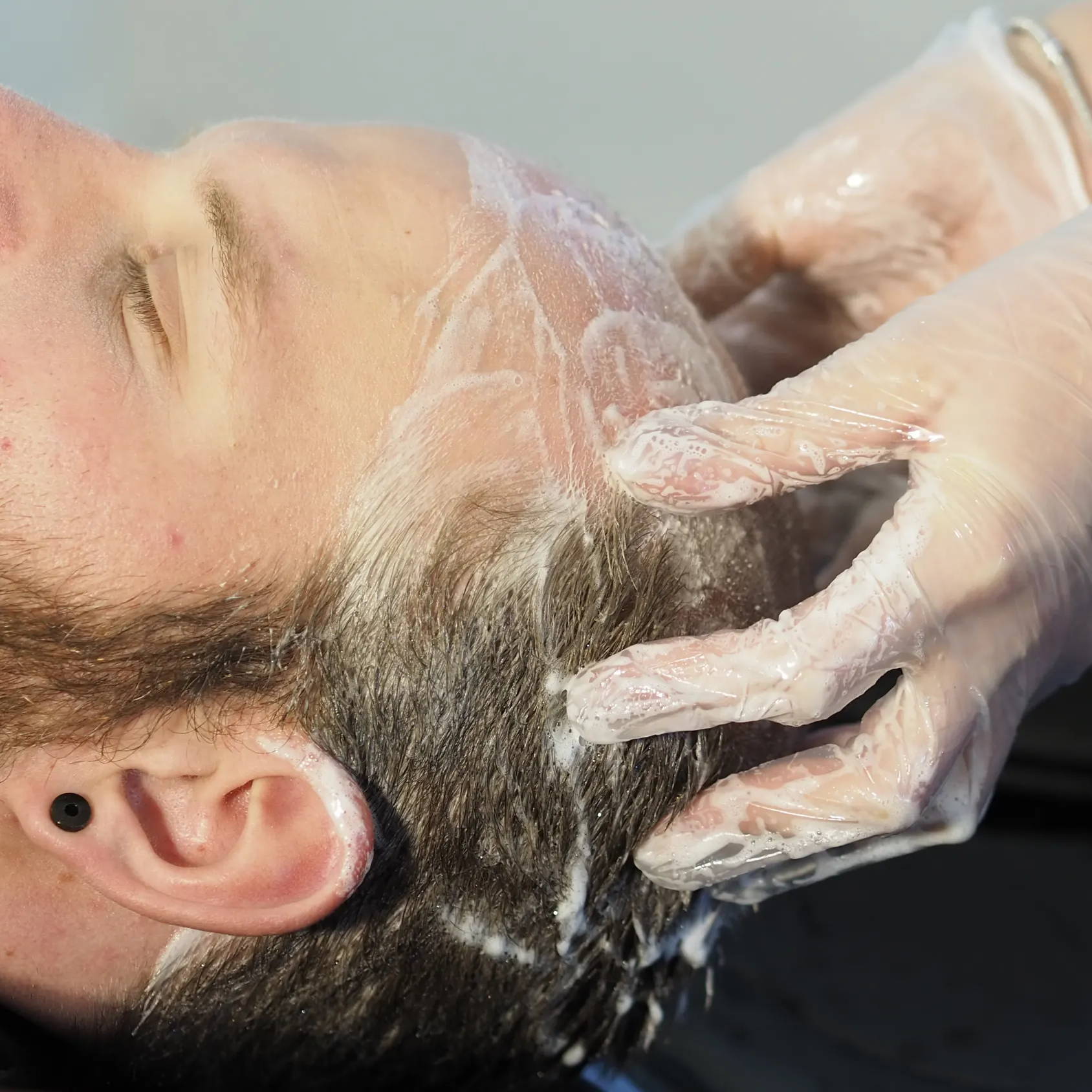 Mann pflegt Kopfhaut und Haare gegen Haarausfall