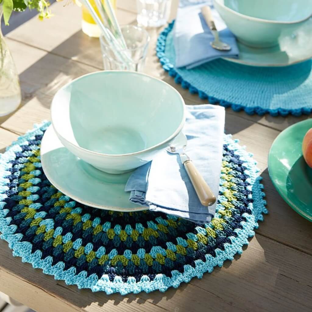 Tischdekoration mit türkisfarbenen Schalen, Servietten und bunten Tischsets.
