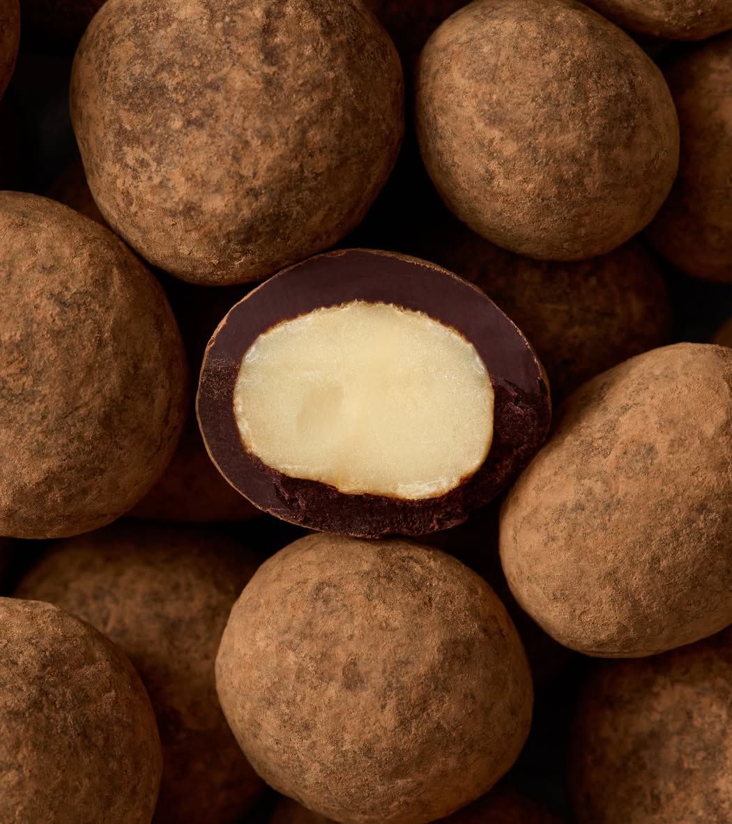 Chocolate-covered candies with one cut open to show the inside.