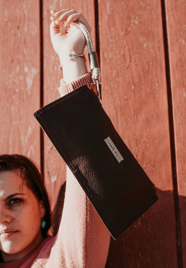 woman holding up leather clutch