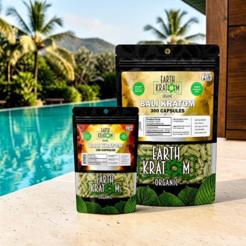Bags of kratom capsules by a pool with palm trees in the background.
