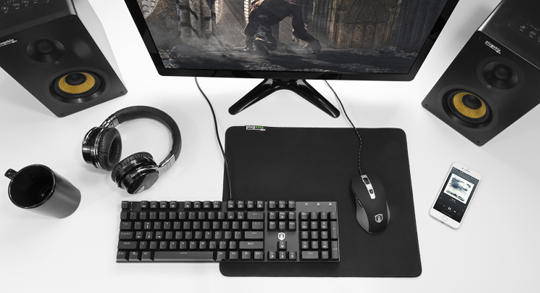 Desk containing computer setup with mouse pad