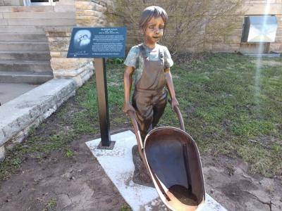 Bronze Children Garden Statues  of a boy pushing a wheelbarow
