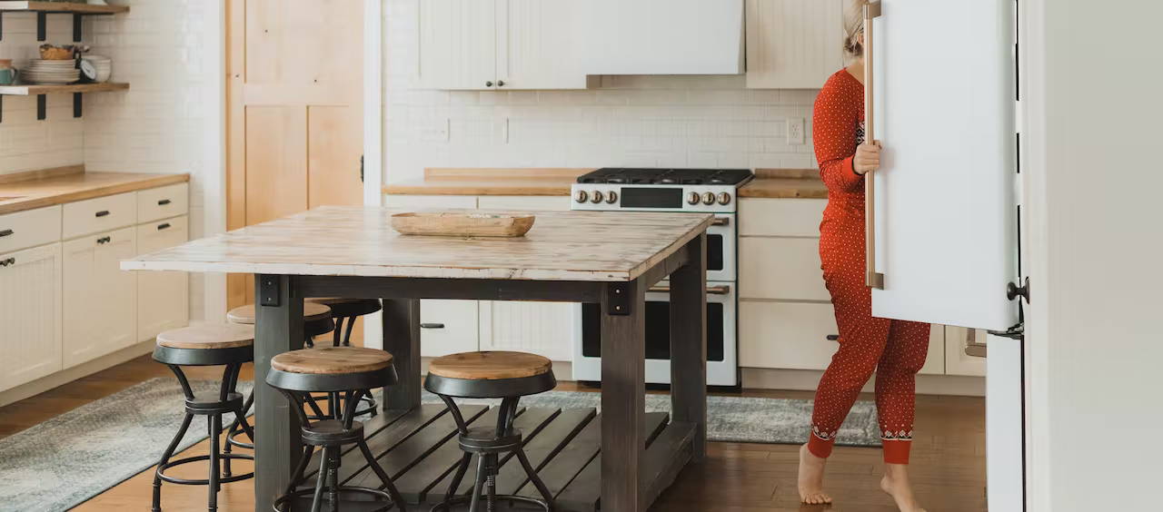 Woman looking in a matte white refrigerator