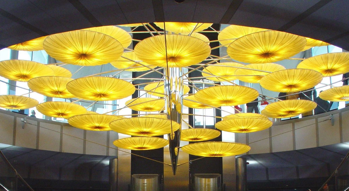Chandeliers shaped like yellow umbrellas hanging from a ceiling.