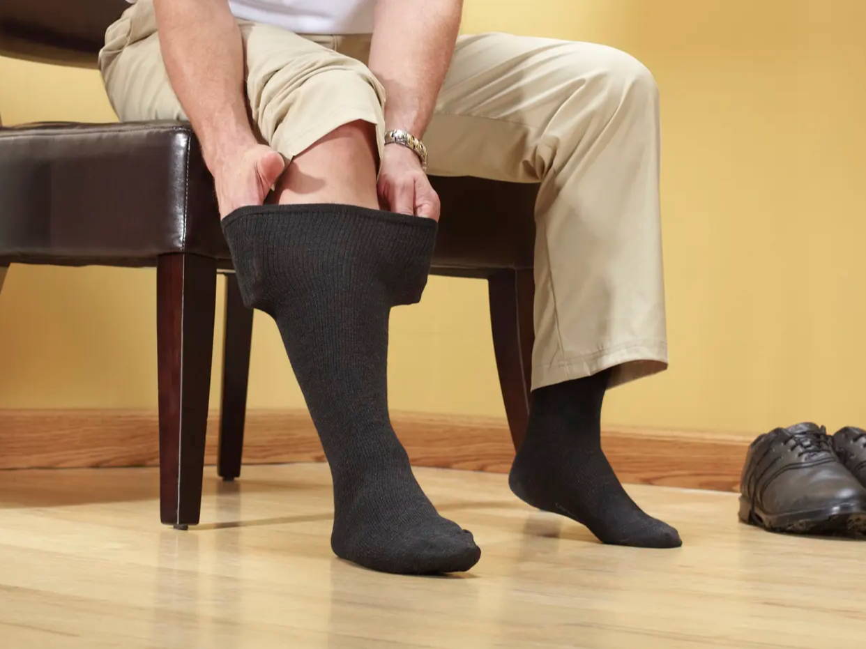 Man putting on Core-Spun Gradient Compression Socks in black