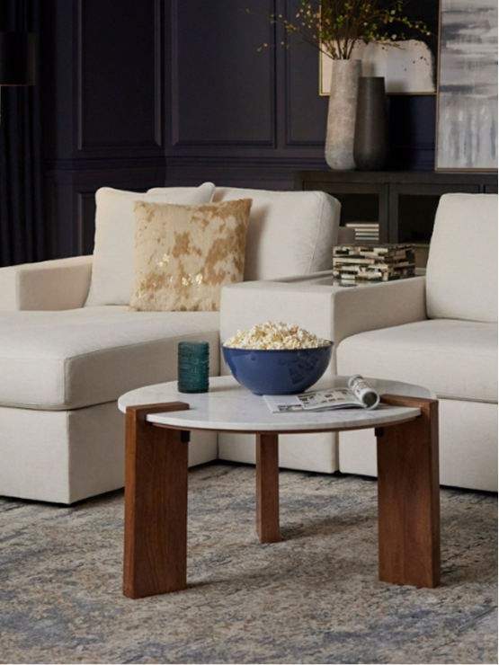 Neutral living room with light seating, dark wall accents, and contemporary coffee table.