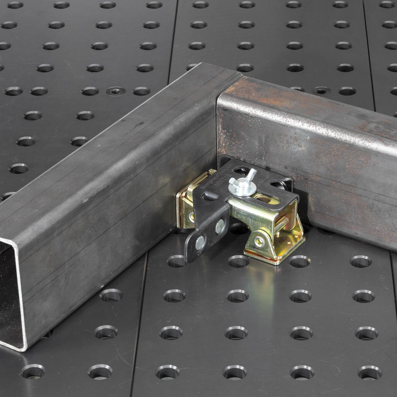 Metal L-shaped bracket with a clamp on a textured surface.