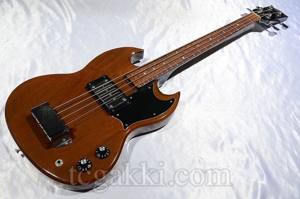 Brown electric bass guitar on a white background.