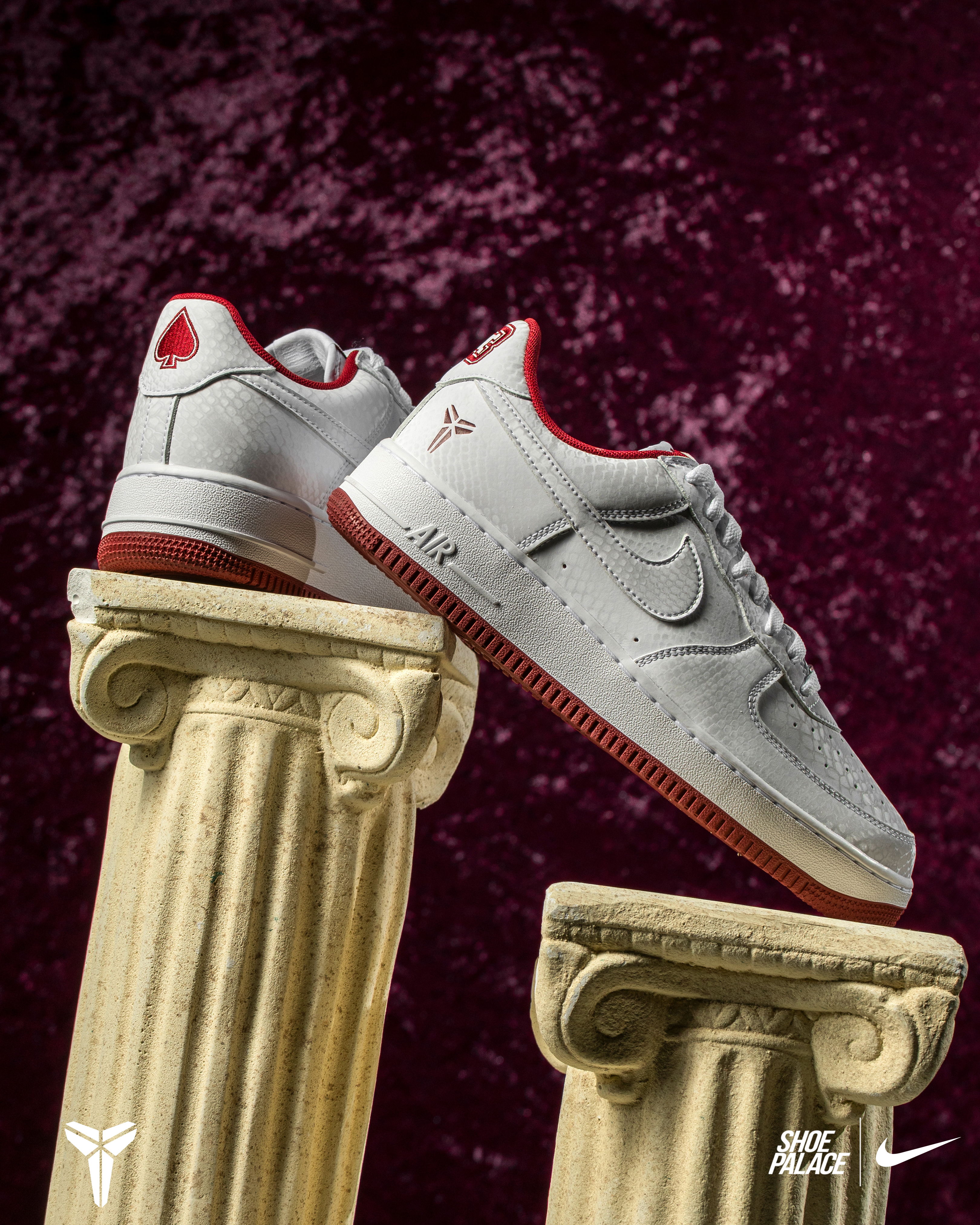 Nike Air Force 1 sneakers displayed on classical columns against a textured background.