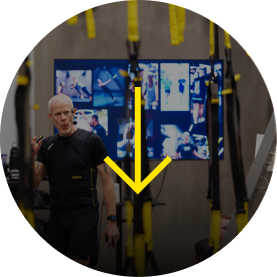 Man demonstrating workout techniques with suspension straps in a gym setting.