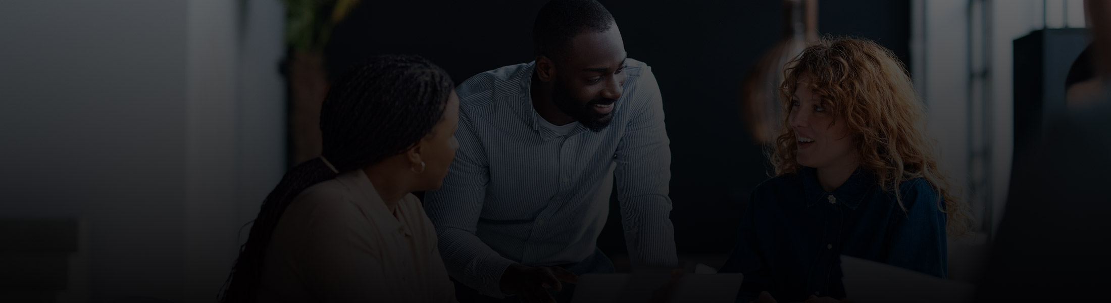 Office professionals collaborating in a modern workspace, representing security and monitoring solutions for office buildings and corporate environments