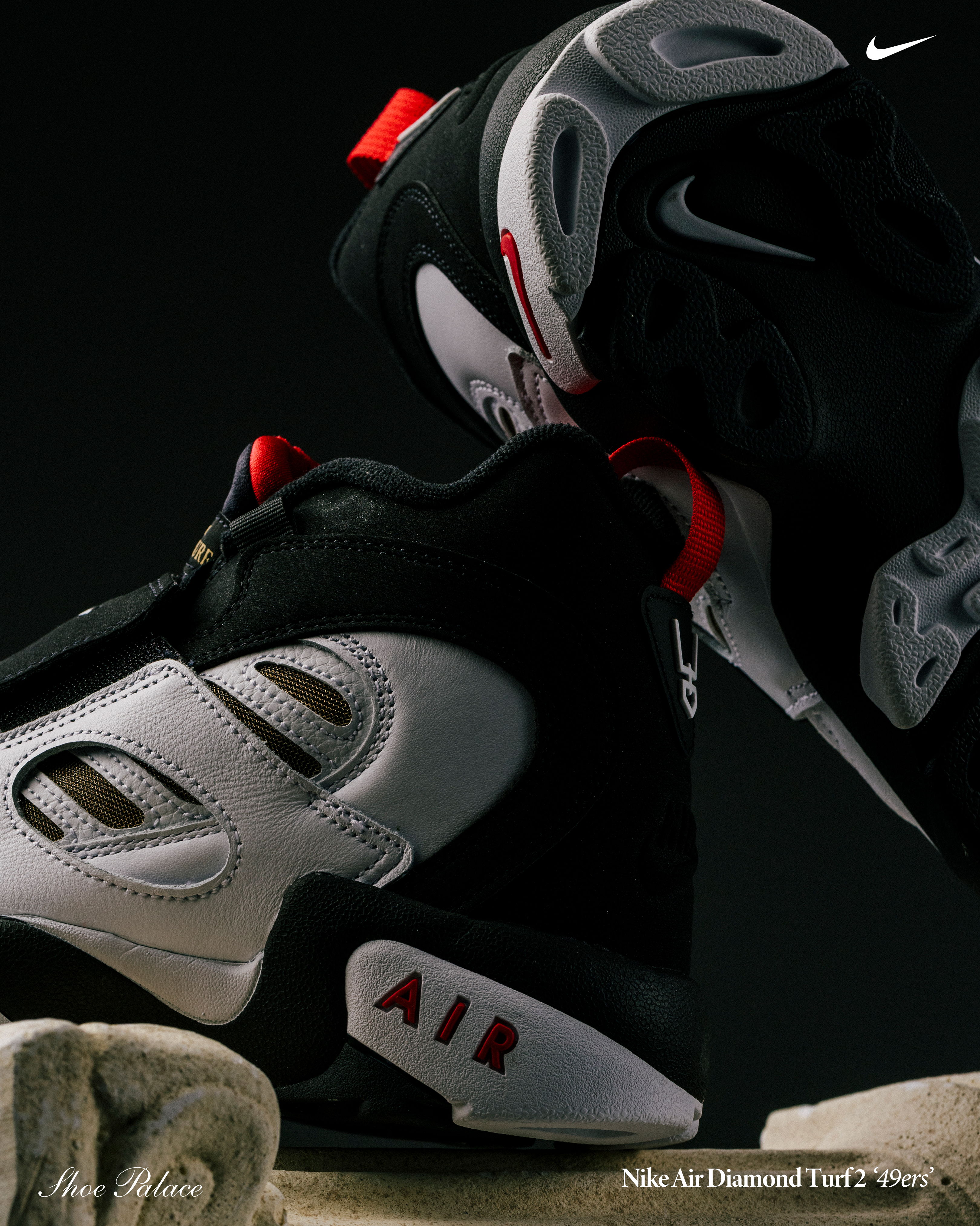 Black and white sneakers with red accents on a dark background.