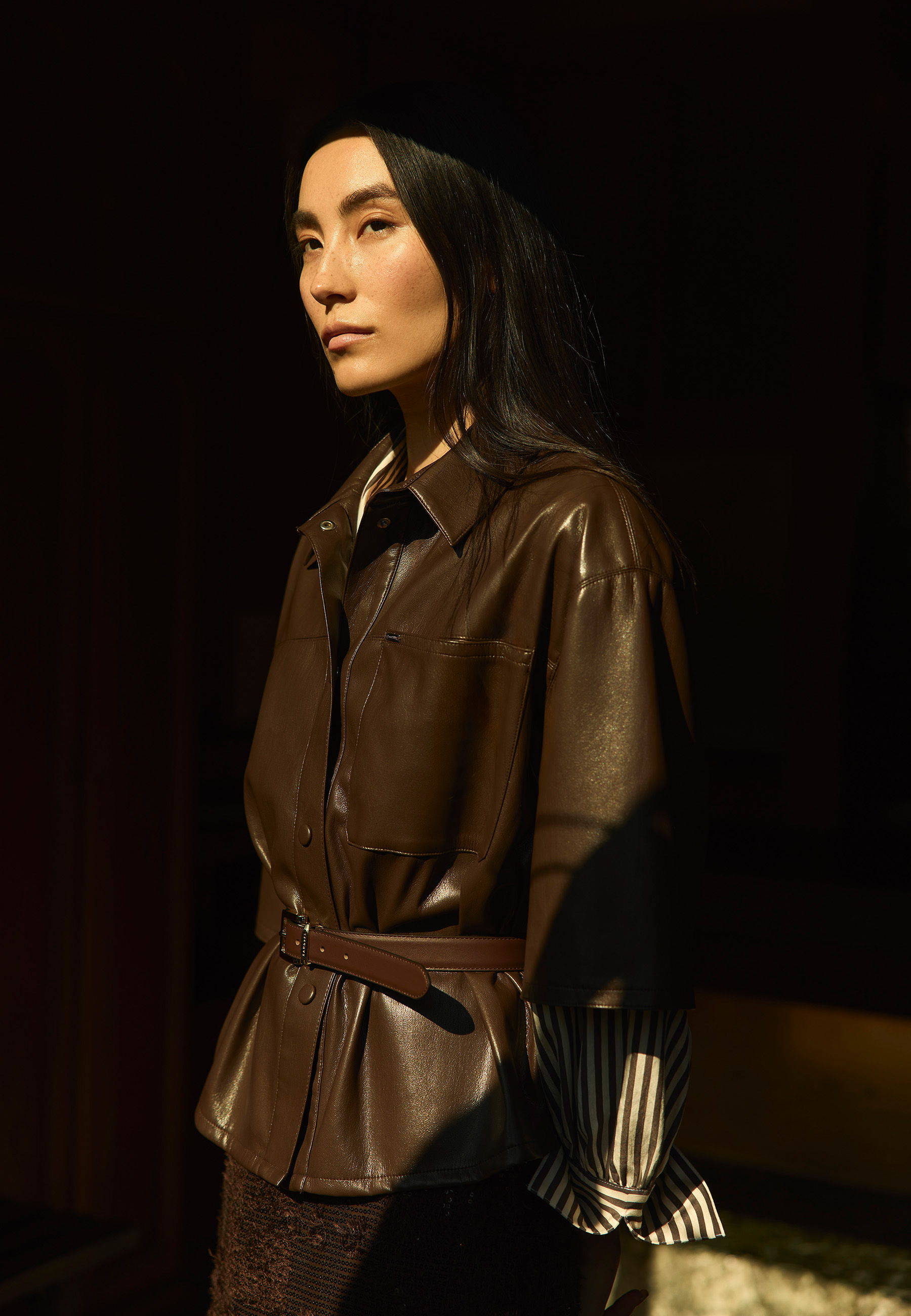 Person in a brown leather jacket with a stylish layered look.