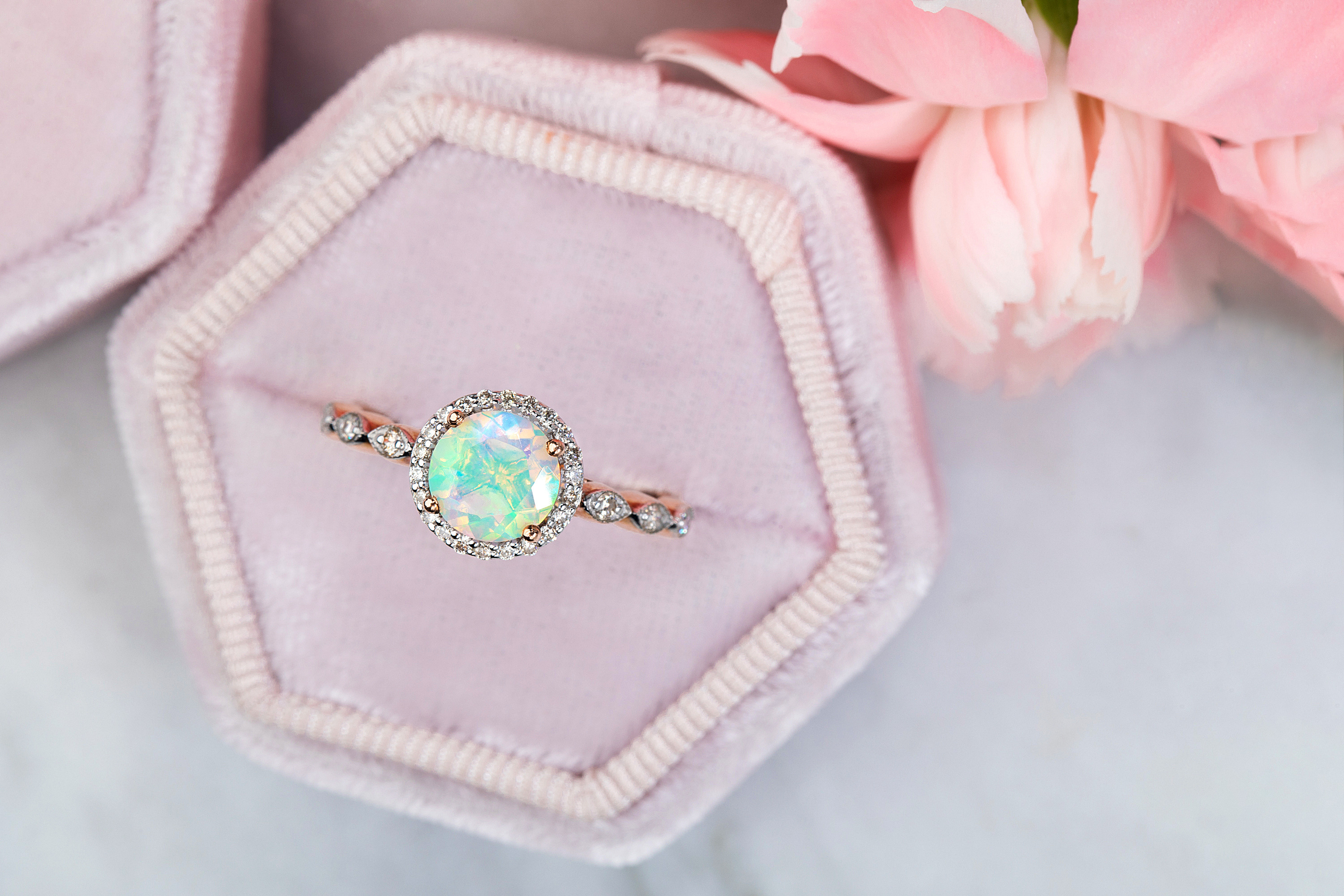 An Open rose ring box is holding the Opal Diamond Ring Soulmate. 