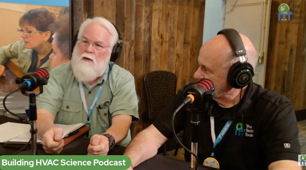 Two men podcasting with microphones and headphones in a studio setting.