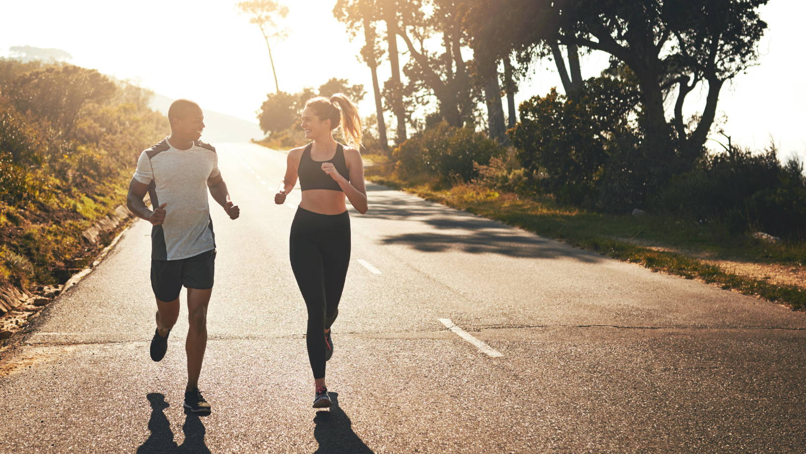 Man and woman jogging along the road