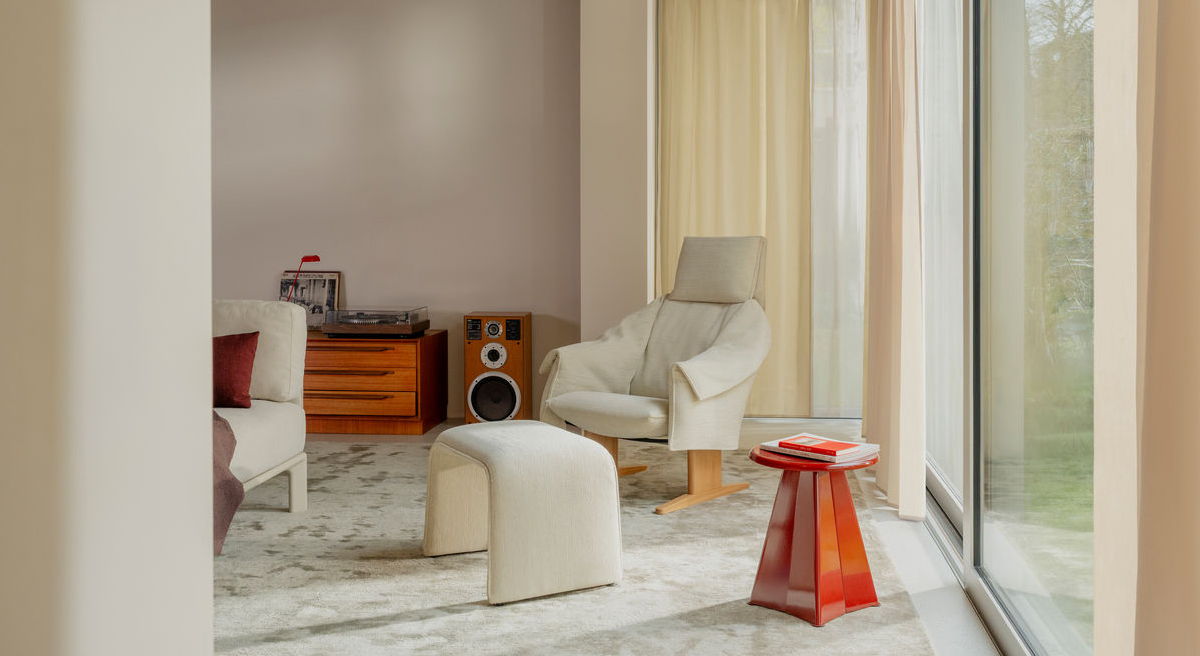 Modern Vitra living room with a Bascule chair, stool, and large windows.