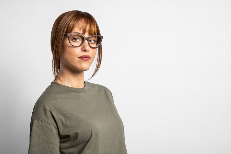 Oval face shape woman wearing Charm Purple, wooden cat eye frames, on a white background