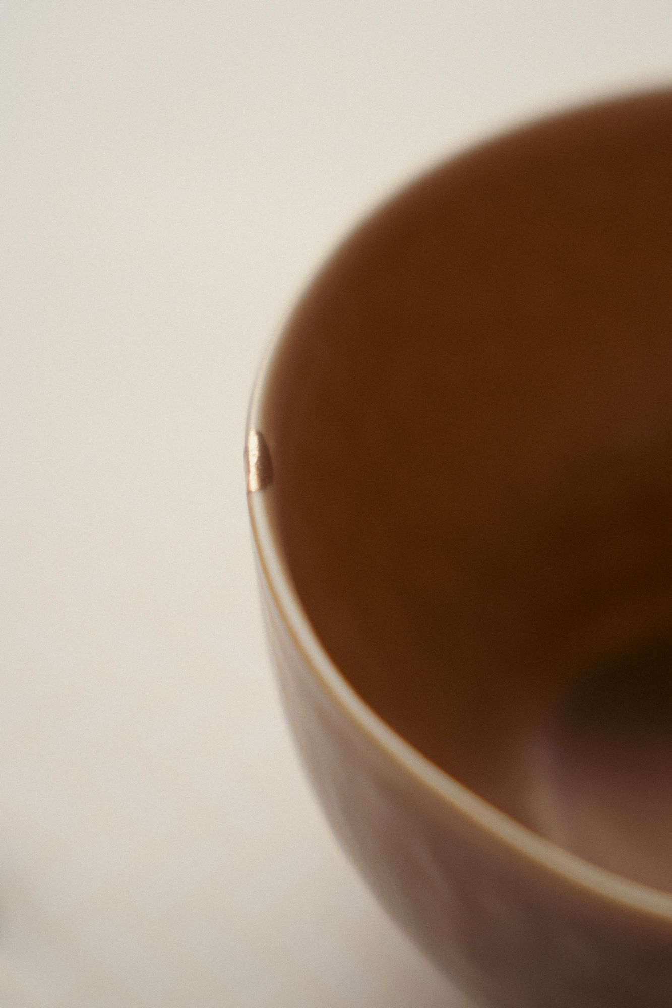 Close-up of a brown ceramic bowl with a small chip.