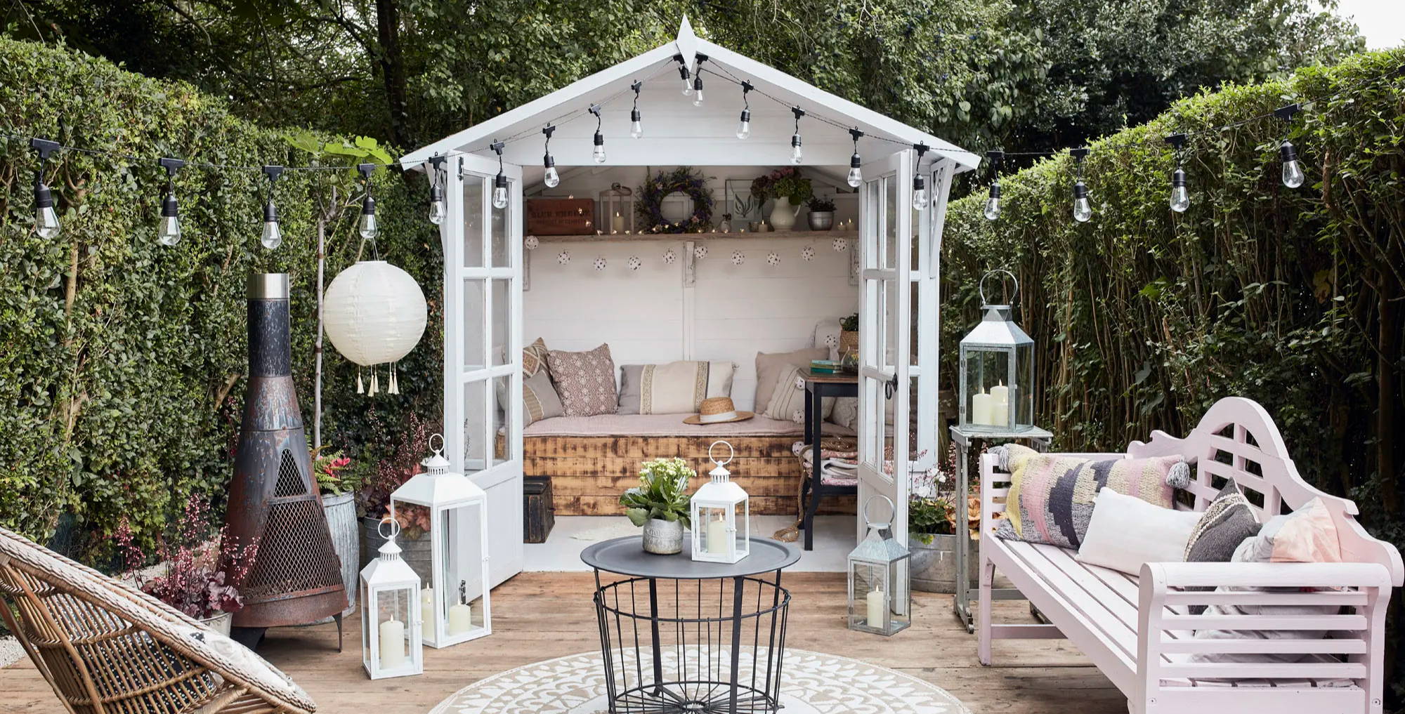 Outdoor decking space featuring a summer house  with festoons and lanterns.