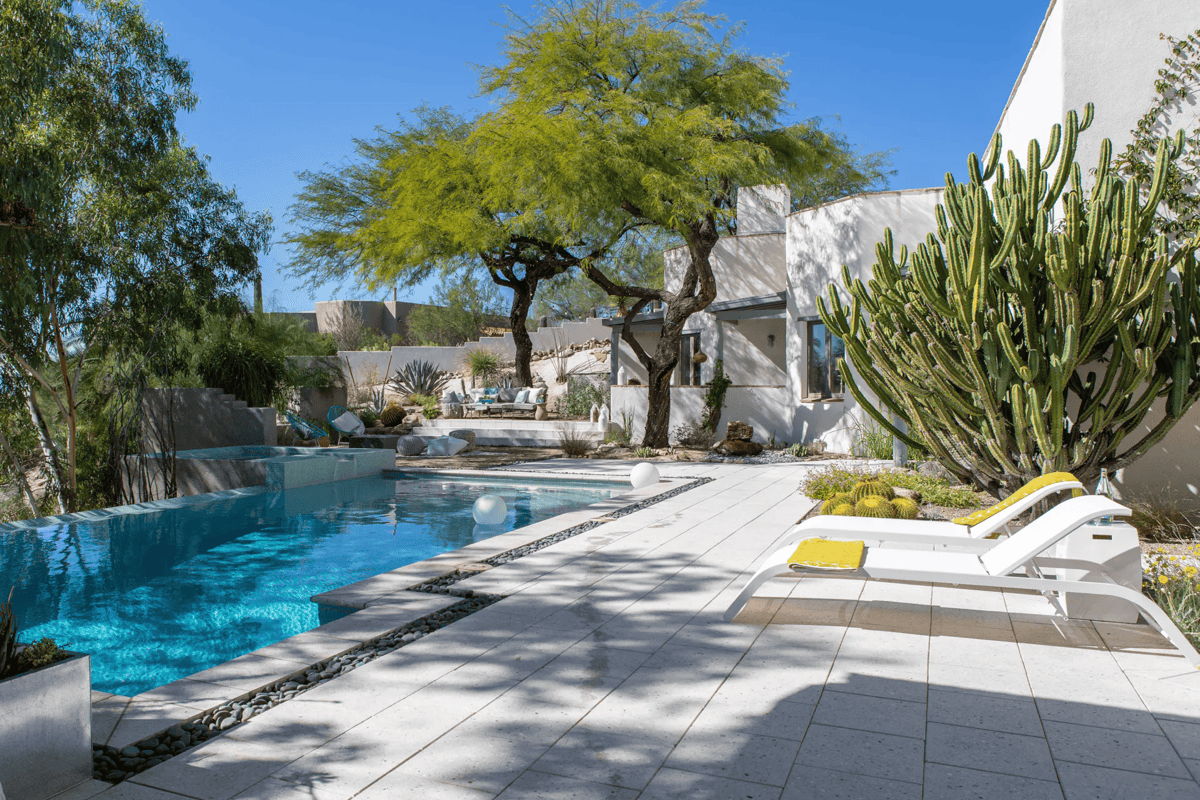 Durable poolside chaise lounges with colorful cushions in a modern desert landscape