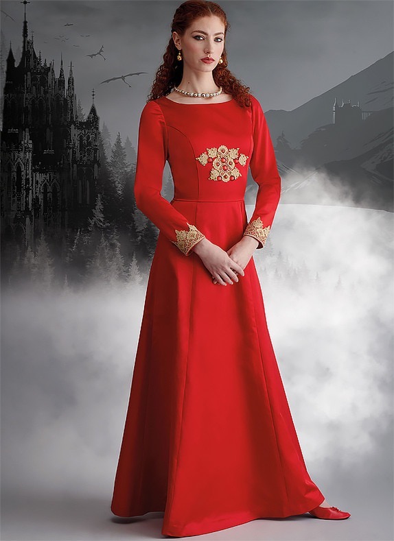 Woman in a long red dress standing against a misty, dark landscape.