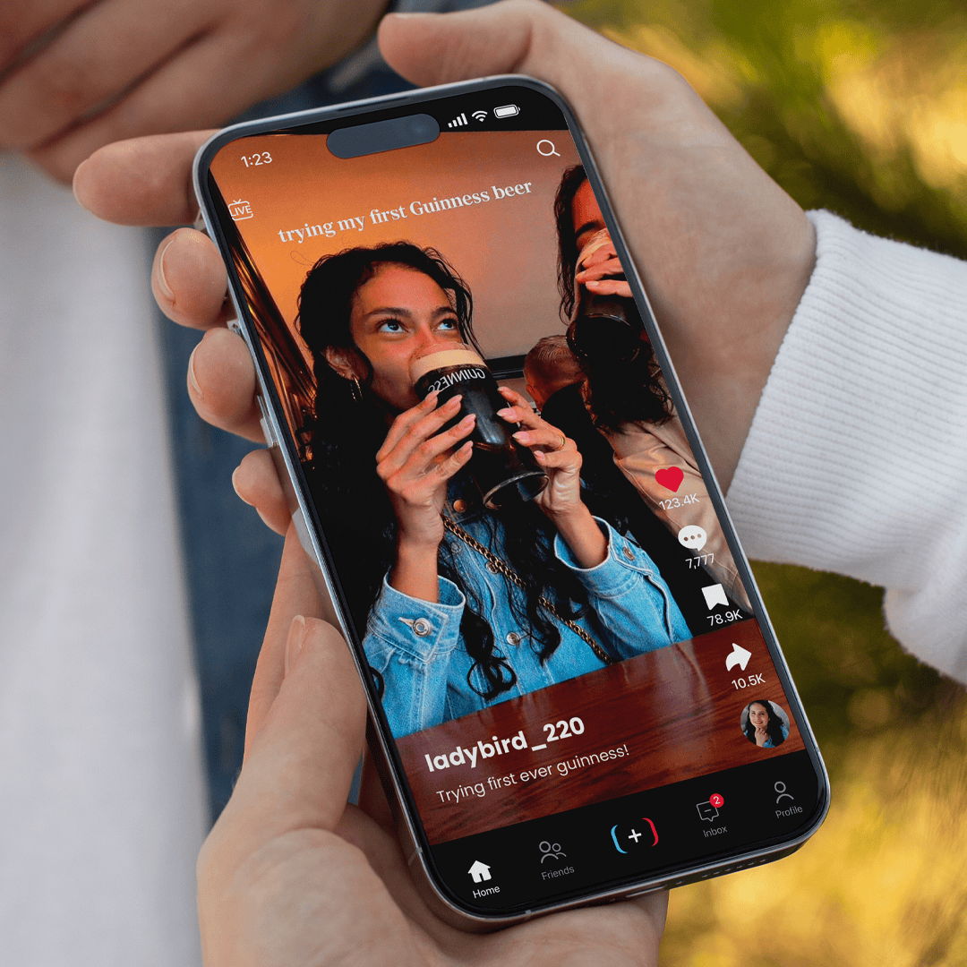 A person holding a phone displaying a video of someone drinking coffee.