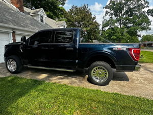 Black Ford F150 side view in driveway