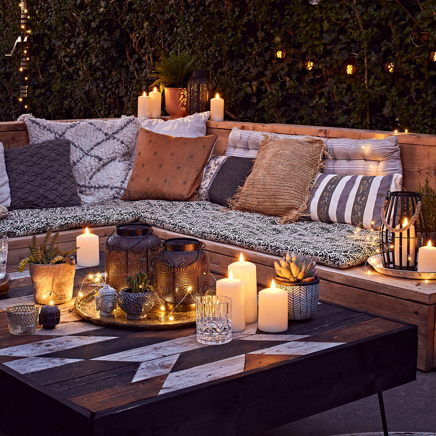 Relaxing garden with sofa set and cushions featuring LED candles
