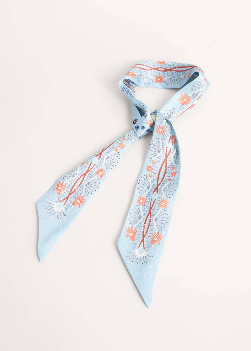 A light blue satin neck scarf with orange pattern detail