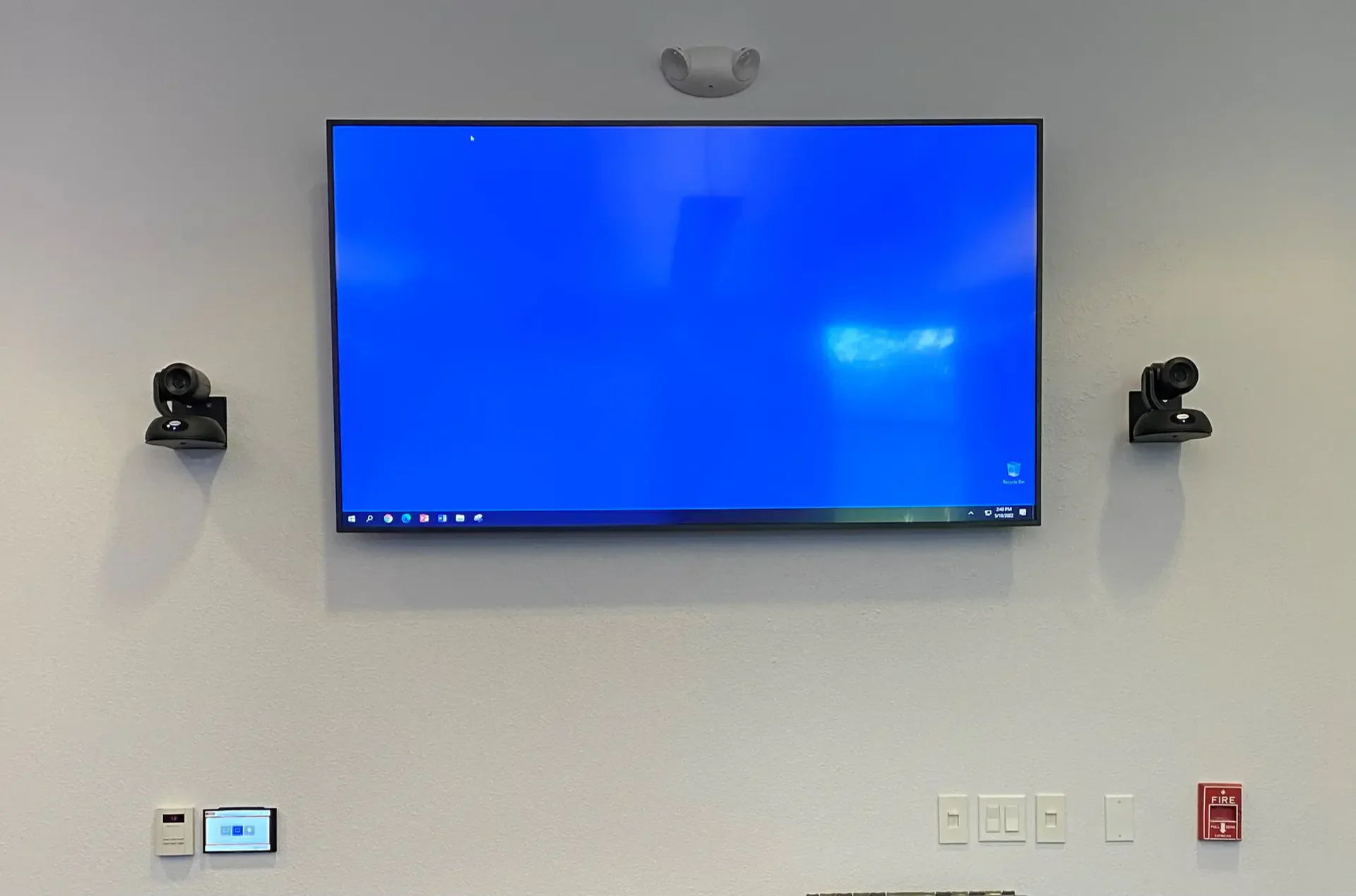 A blank blue screen on a wall-mounted TV with cameras.