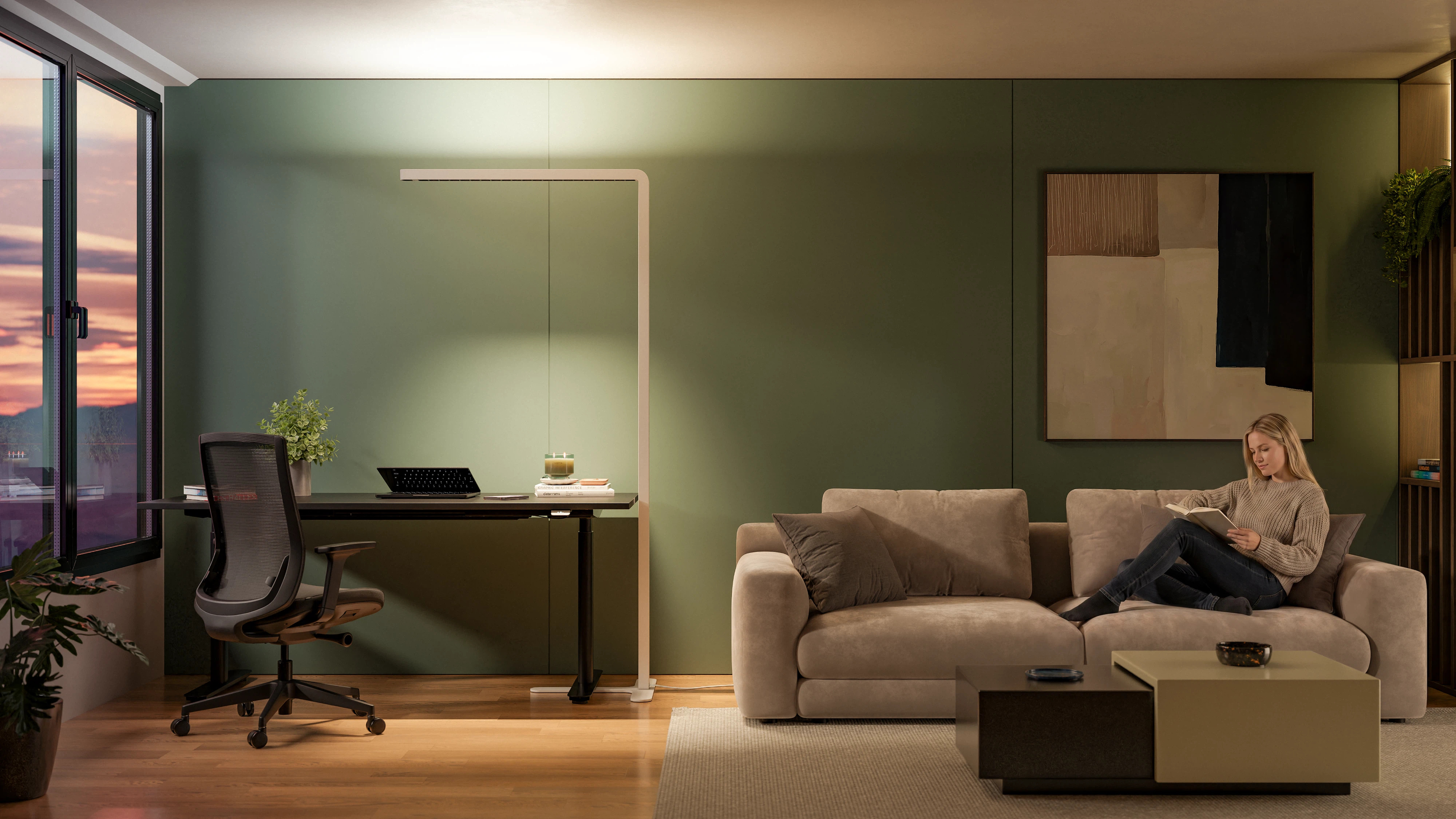 A white " Lumino " Pro floor lamp illuminates a home office workspace next to a living area with a sofa.