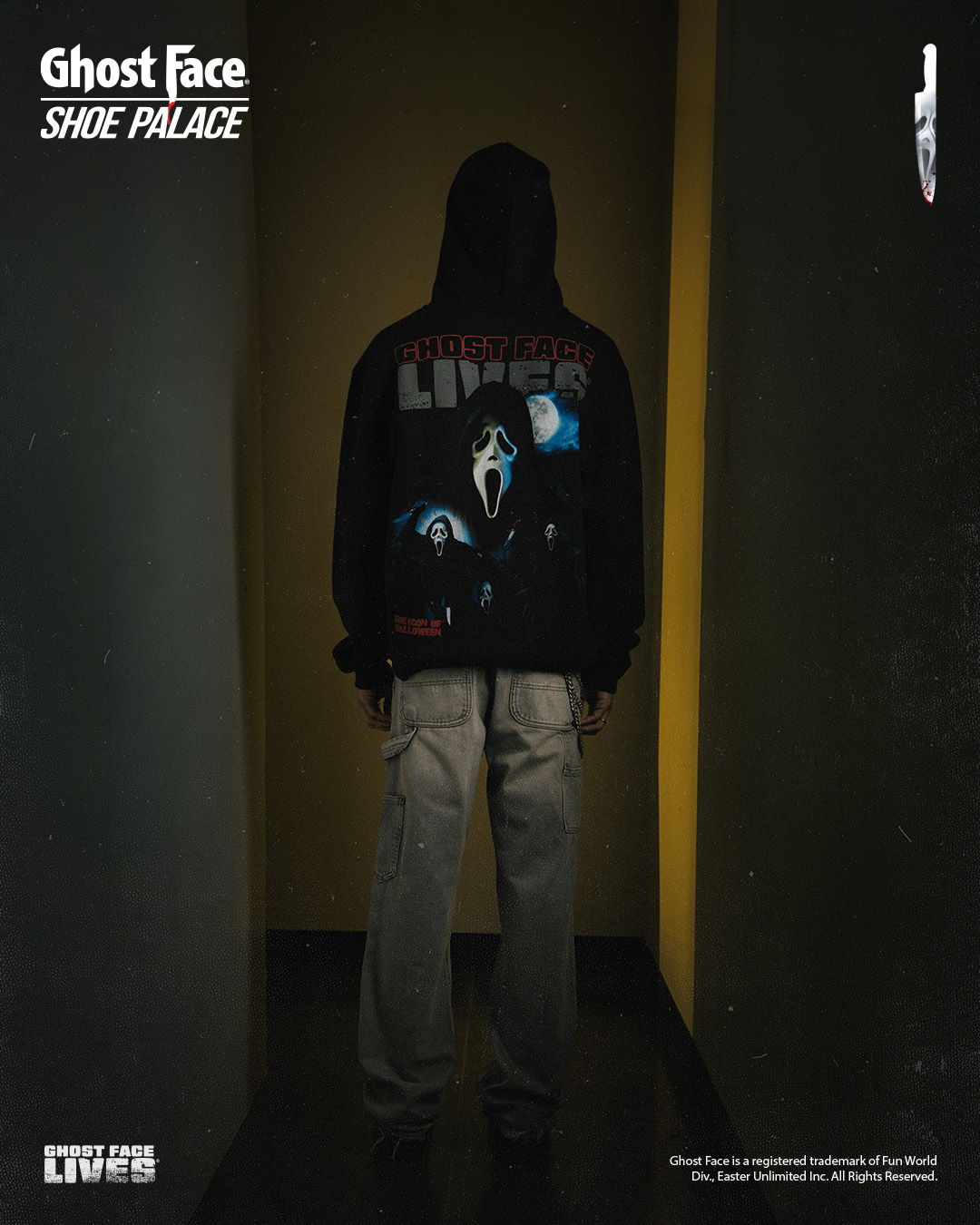 Person wearing a Ghost Face hoodie standing in a dimly lit hallway.
