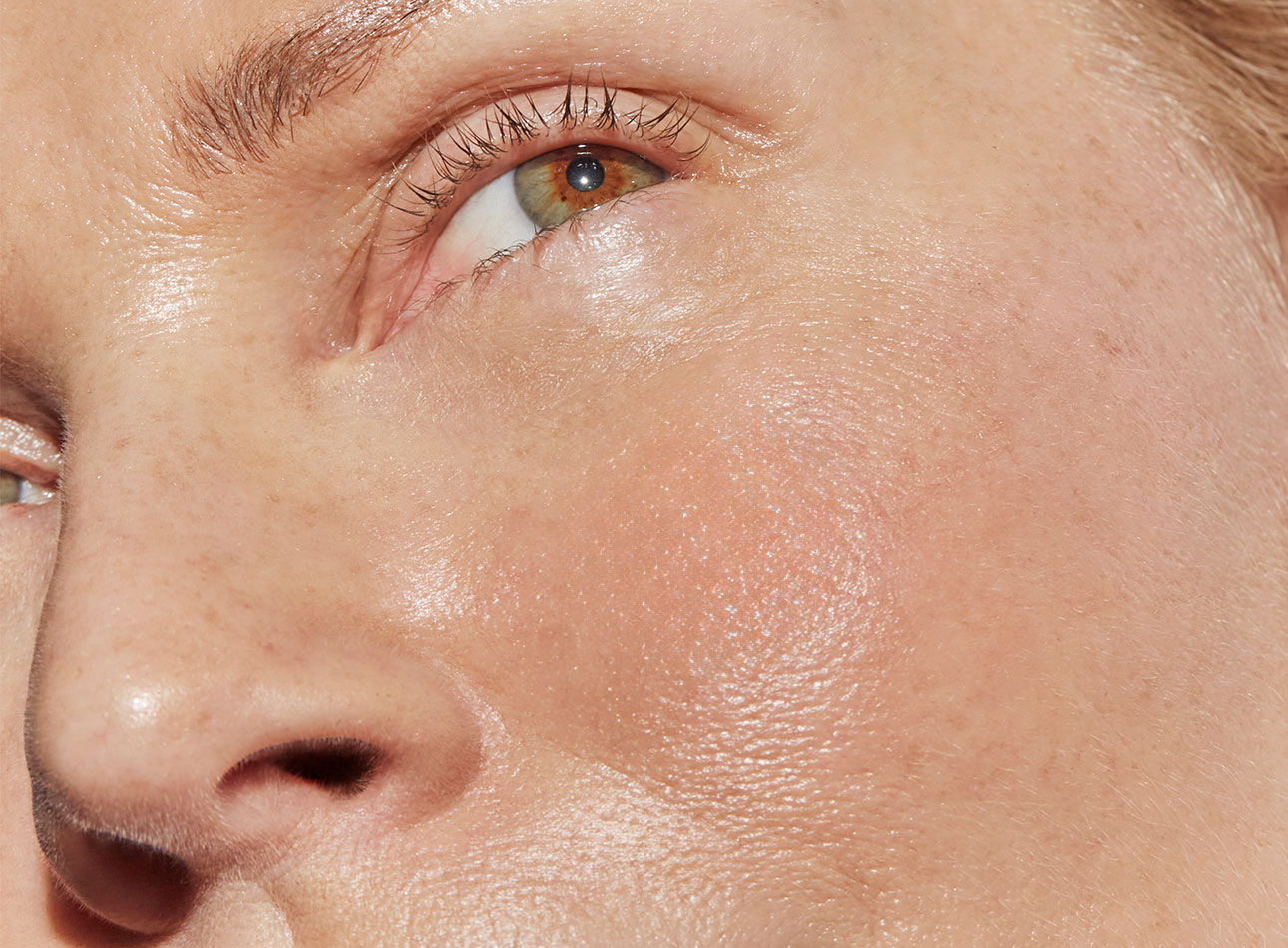 Close-up of a person's face focusing on the eye and skin texture.