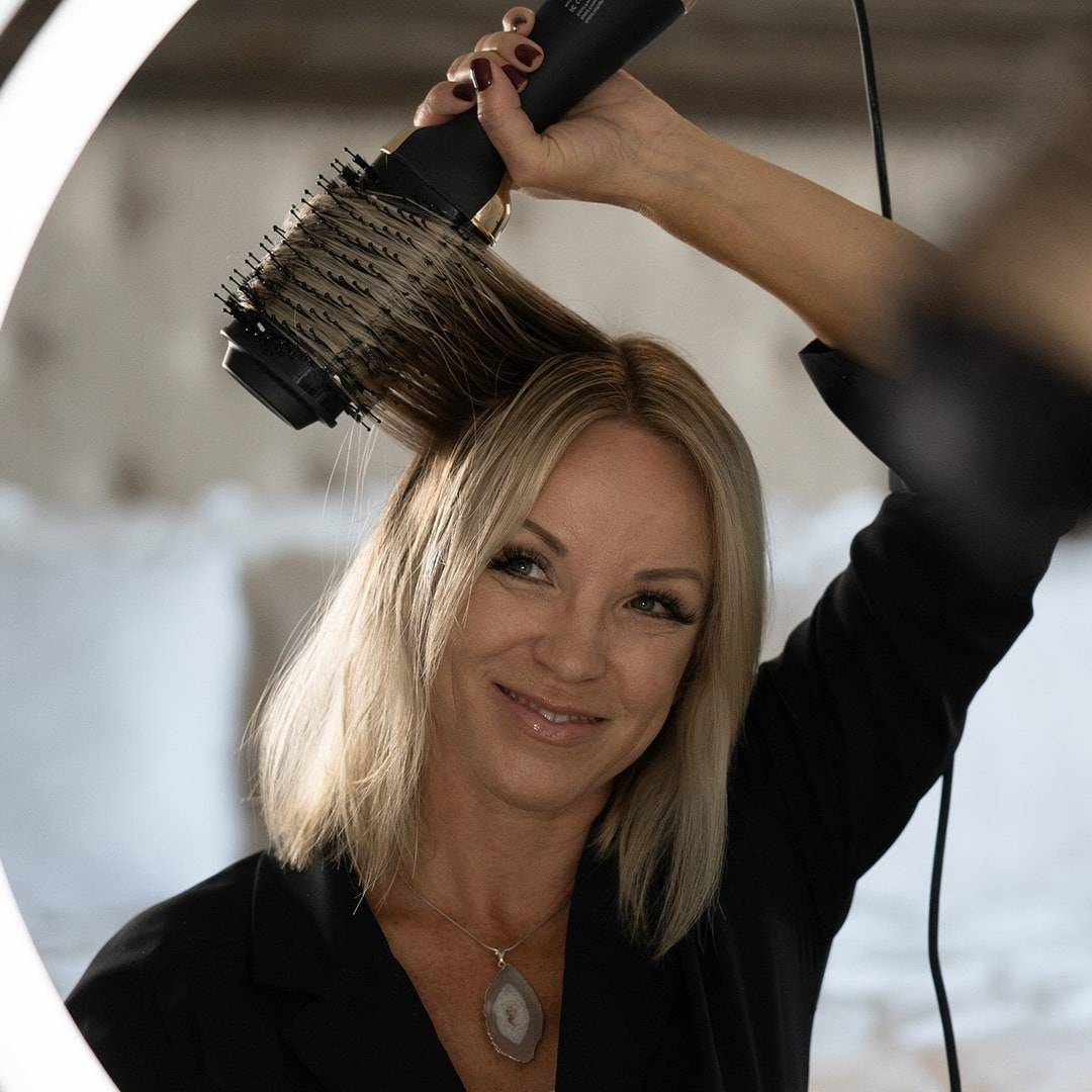 Blonde woman drying hair with Blow Brush 