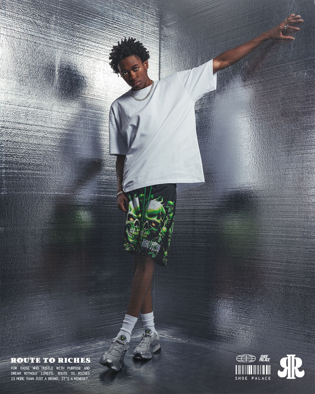 A person in a white shirt and patterned shorts poses confidently.