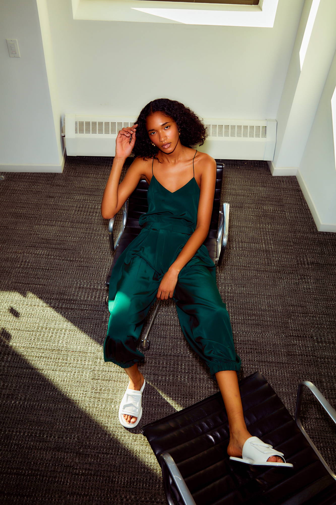 A woman in a green outfit sitting on a chair.