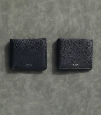 Two black wallets displayed on a textured gray background.