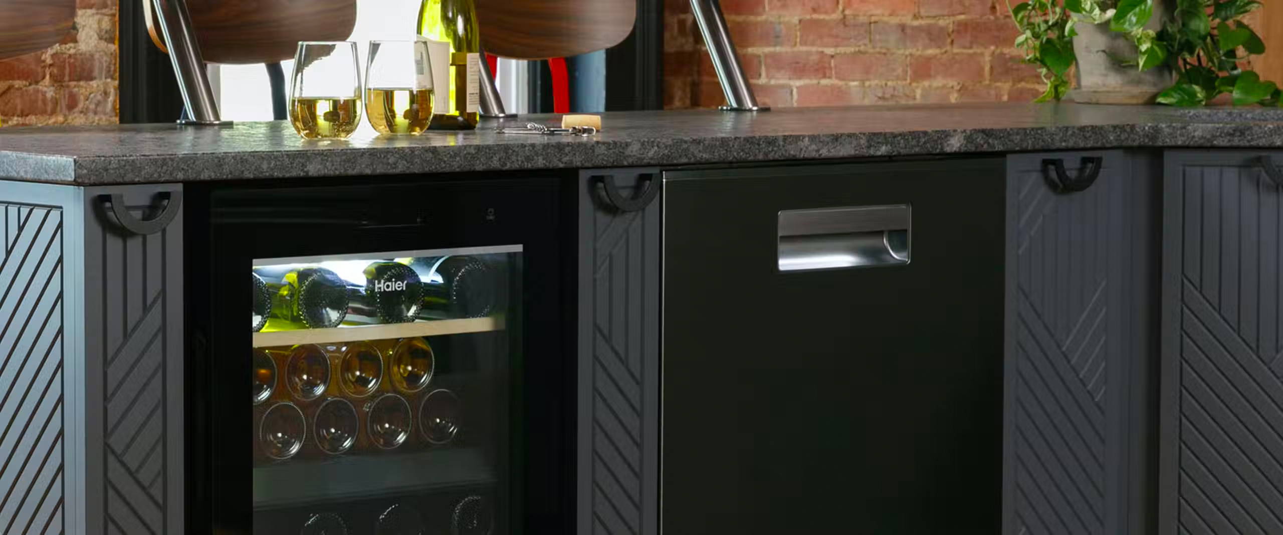 Wine center installed in a kitchen island, with two classes of white wine on the countertop