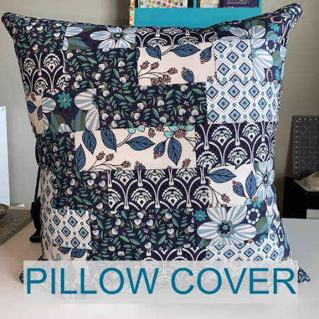 A quilted pillow cover made out of blue printed fabrics finished with a french seam