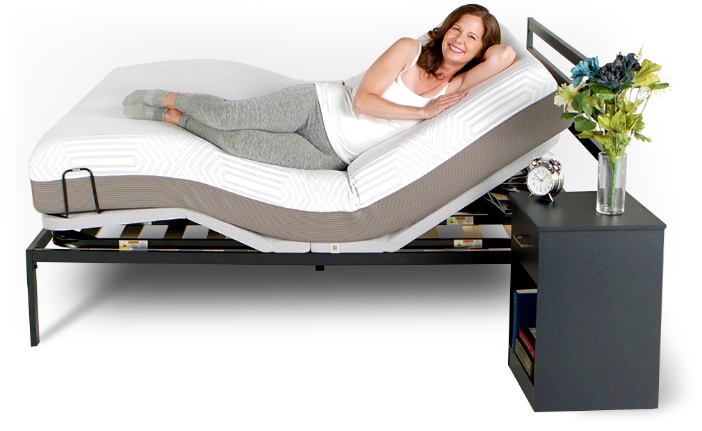 A brunette woman laying on an adjustable bed with the head and foot sides raised, looking at the camera and smiling 