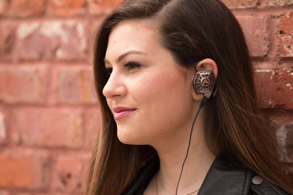 Female model enjoying her music through a  pair of Open Back Audeze iSINE10 In-Ear headphones.