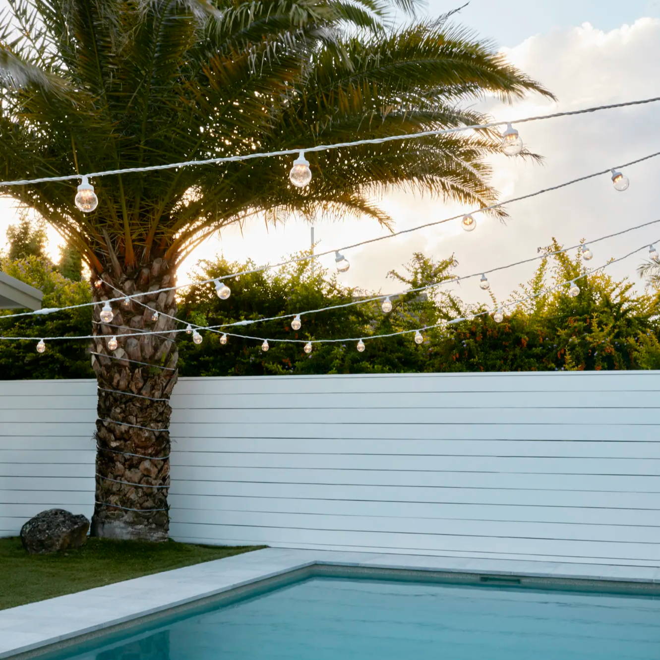 White festoons draped over a swimming pool setting
