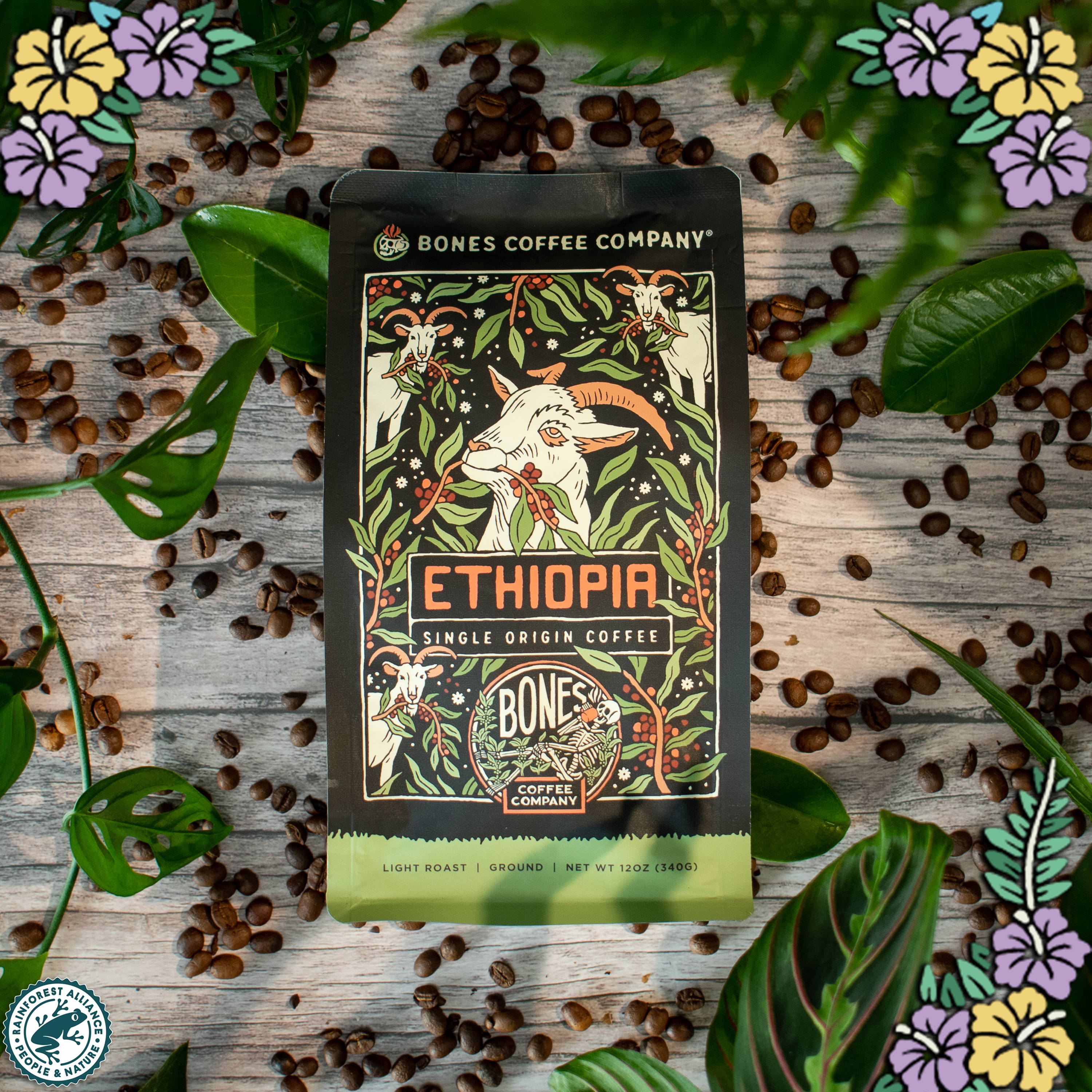 A 12 ounce bag of coffee from Ethiopia that has art of a goat on it. There are flowers in the top left, top right, and bottom right. There's also the logo for the Rainforest Alliance in the bottom left.