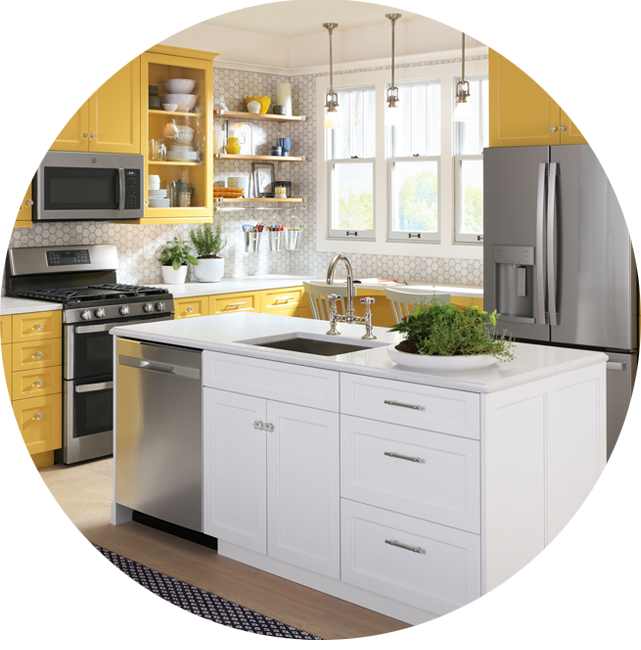 Modern kitchen with yellow cabinets, stainless steel appliances, and a white island.