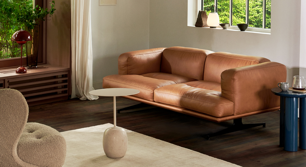 Modern living room with a brown leather Inland Sofa by &Tradition and minimalist decor.