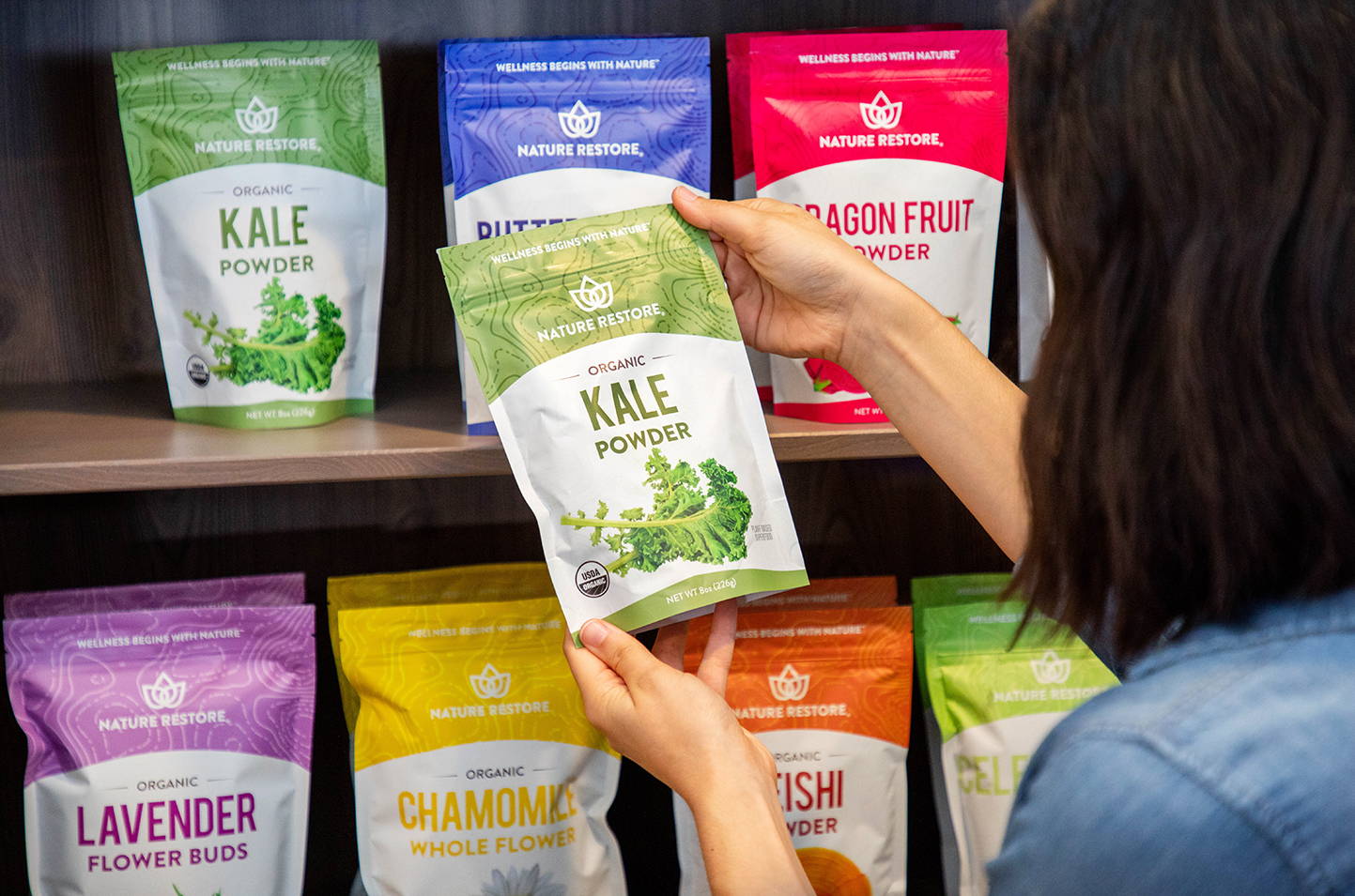 Woman holding Nature Restore powder off shelf